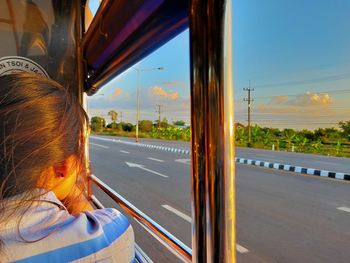 Rear view of woman seen through car window