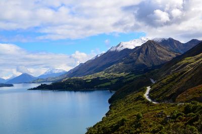 Scenic view of mountains and lake against cloudy sky