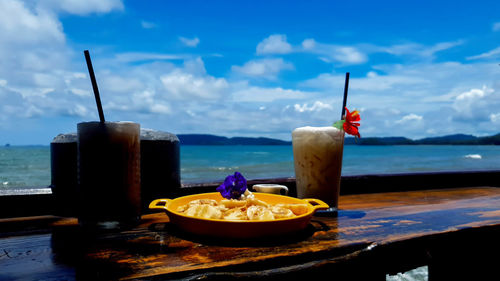 High angle view of breakfast on table by sea against sky