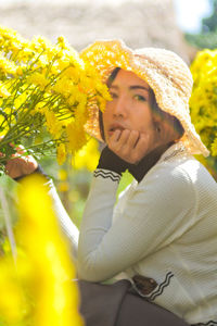 Portrait of smiling woman with yellow flower