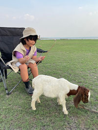 Side view of boy with dog on field