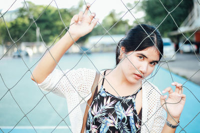 Portrait of woman seen through net in court