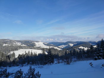 Scenic view of snowcapped mountains against blue sky