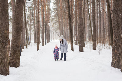 Rear view of people on snow covered land