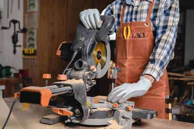 Midsection of man working at workshop