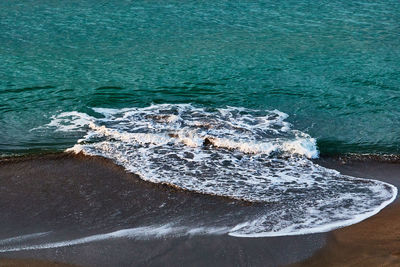 High angle view of sea waves splashing at the beach