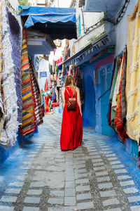 Rear view of woman walking on street market