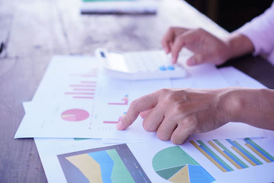 Midsection of man holding paper on table
