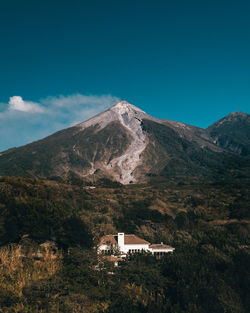 House on mountain against sky