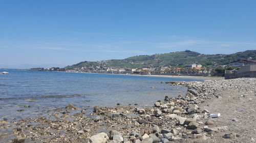 Scenic view of sea by buildings against sky