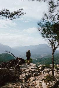 Rear view of man on mountain against sky
