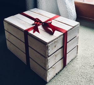 Close-up of ribbon tied wooden gift container on carpet