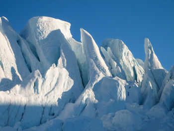 Sharp jagged glacial seracs of the matanuska glacier contrasted against a bluebird sky and no people