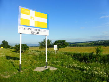 Information sign on field against sky