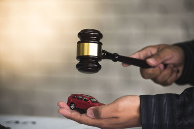 Close-up of lawyer hand holding gavel at desk in courtroom