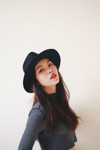 Portrait of beautiful young woman against white background