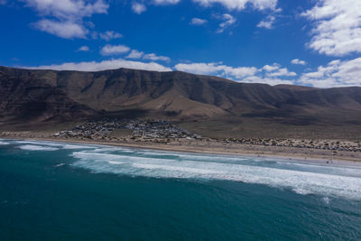 Panorama of the empty road through sandy and volcanic desert,lanzarote. view on the caleta de famara