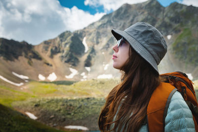 Side view portrait of a woman standing and breathing fresh air in the mountains. profile of a female