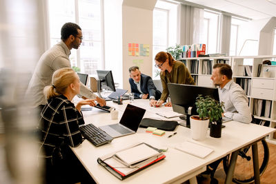 Sales professionals brainstorming over business plans in office