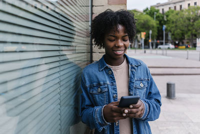 Young woman using mobile phone in city