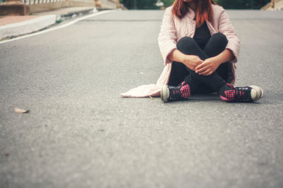 Woman sitting on road