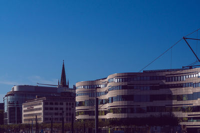 Low angle view of buildings against clear blue sky