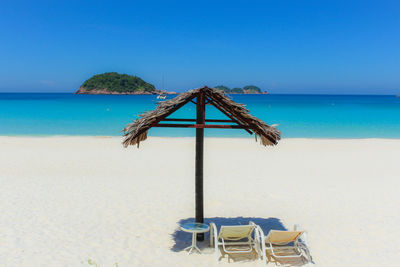 Lifeguard hut on beach against clear blue sky