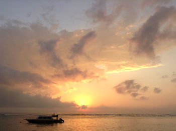 Lone boat in calm sea against scenic sky