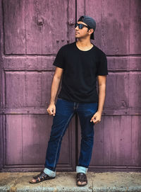 Young man standing against wall