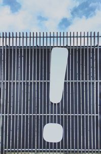 Low angle view of metal fence against sky