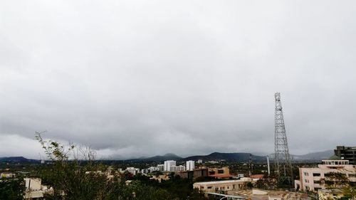 Houses in town against cloudy sky