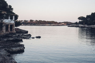 Scenic view of sea by buildings against clear sky