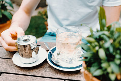 Midsection of man holding drink on table