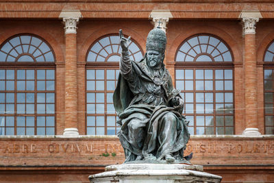 Low angle view of statue against historic building