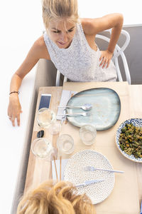 Midsection of woman with drink on table