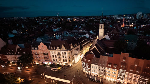 High angle view of illuminated street amidst buildings at night