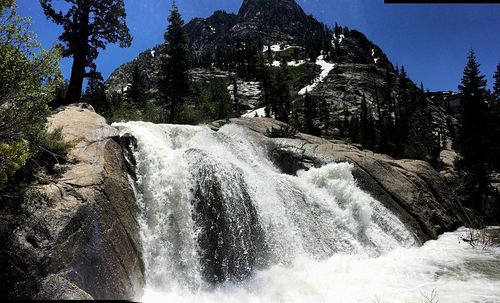 Scenic view of waterfall in forest against clear sky