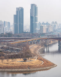 Bridge over river in city against sky