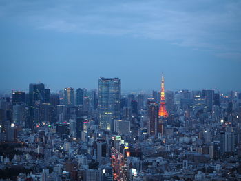 Illuminated buildings in city against sky