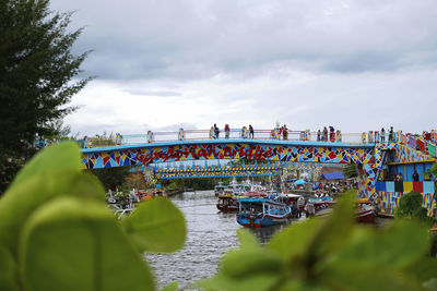 People on bridge against sky