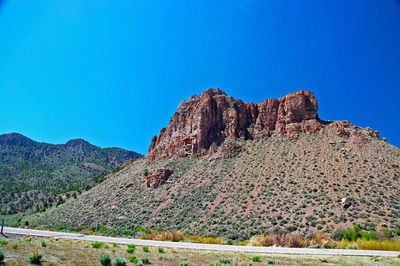 Scenic view of rocky mountains against blue sky