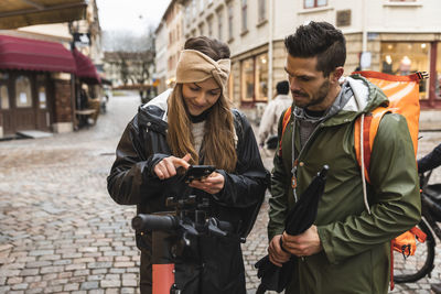 Friends standing on street in city during winter