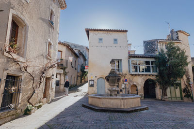 People on street amidst buildings against sky