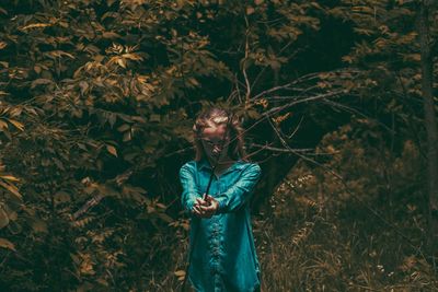 Full length of young woman standing in autumn leaves