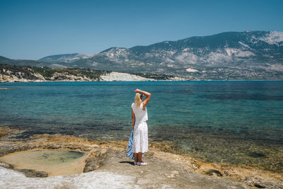 Full length of man standing in sea against mountains