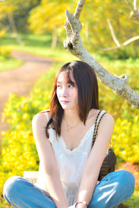 Portrait of young woman sitting on field