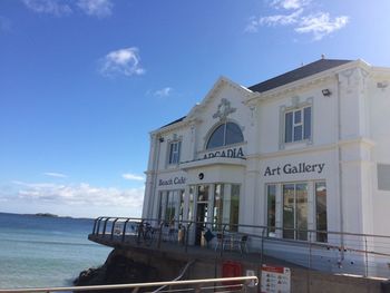 Built structure by sea against sky