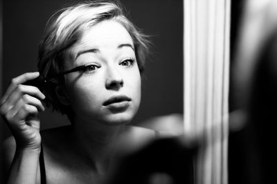 Close-up portrait of young woman looking at home