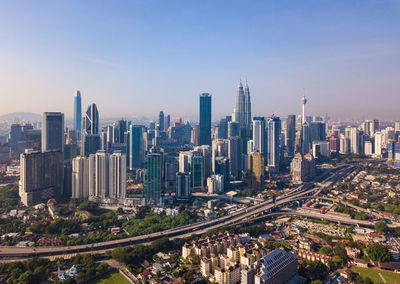 Aerial view of buildings in city against sky