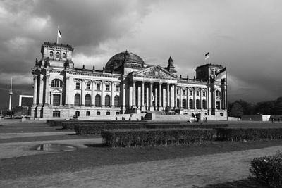 Facade of historical building against cloudy sky